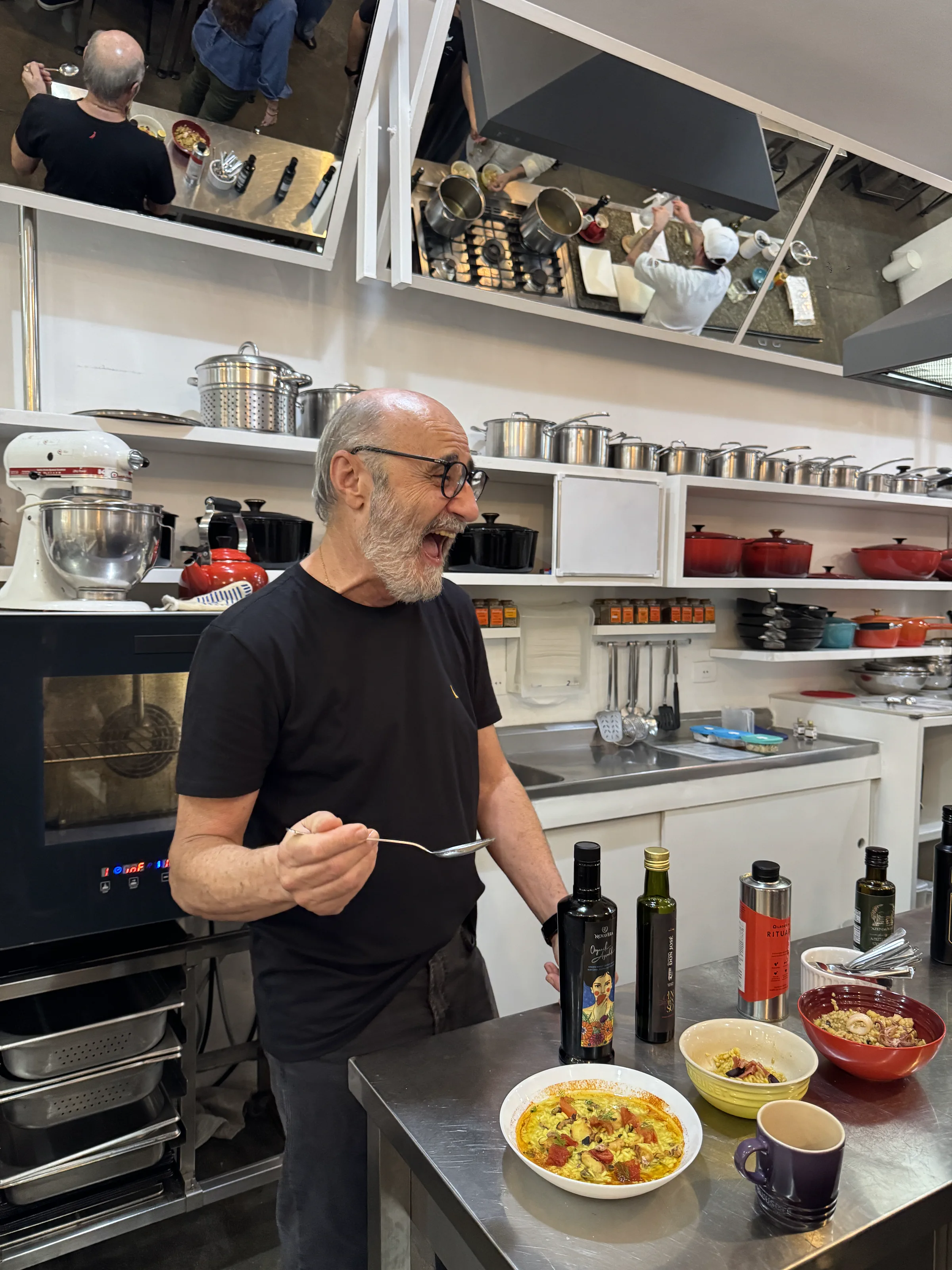 Professor orienta a turma diante de pratos e garrafas de azeite na cozinha