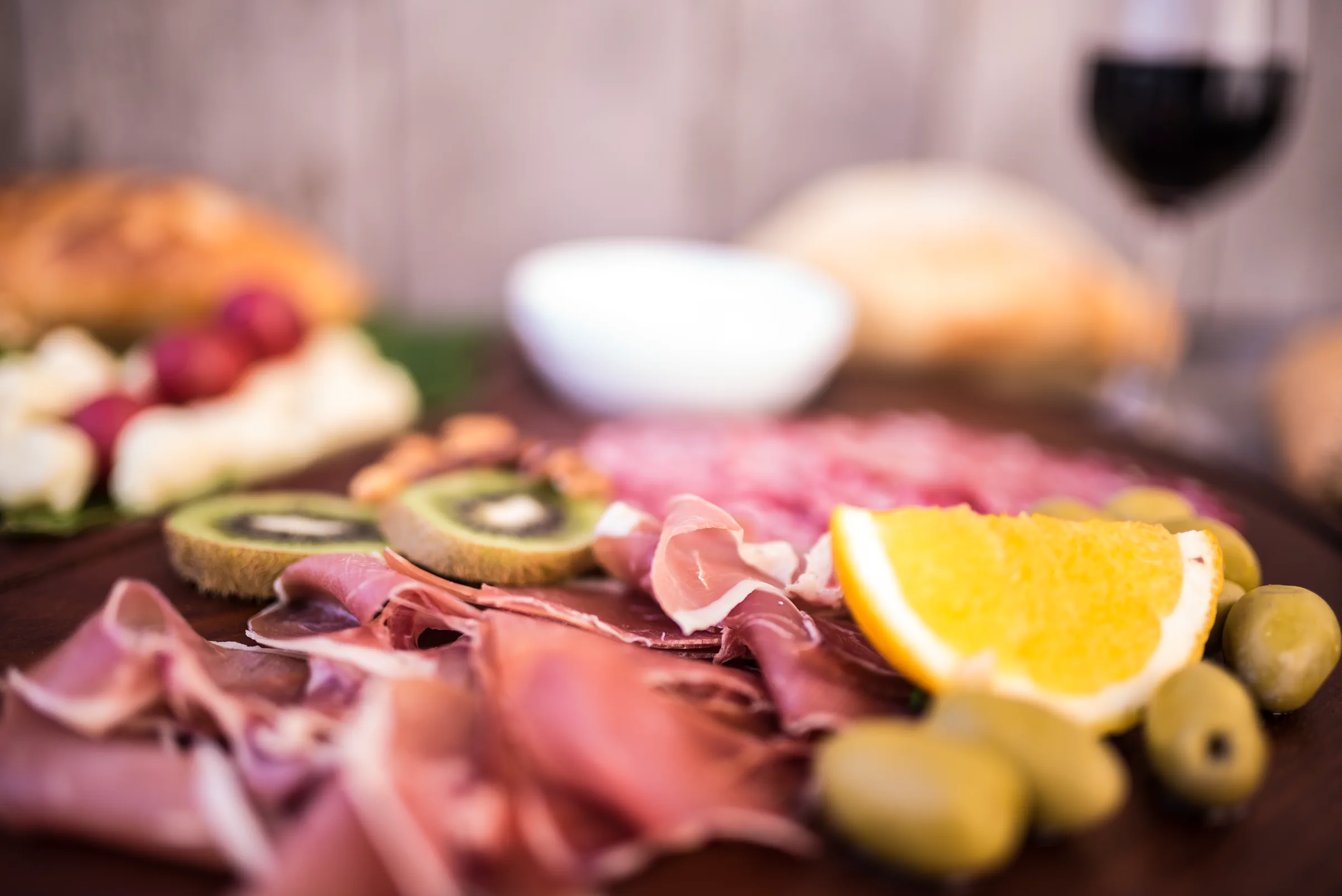 Composição gastronômica com queijos, frutas, embutidos e azeitonas para harmonização